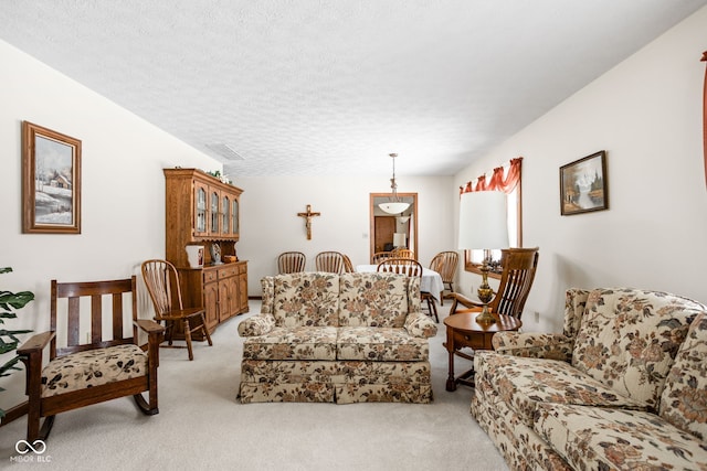 living room featuring light colored carpet and a textured ceiling