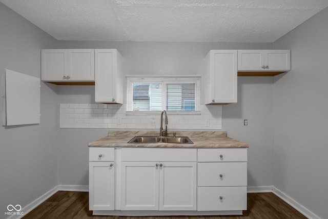 kitchen featuring white cabinetry, sink, tasteful backsplash, and dark hardwood / wood-style floors