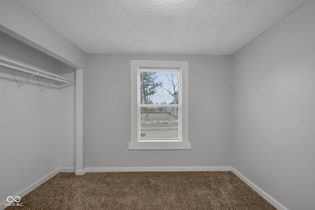 unfurnished bedroom with a textured ceiling and carpet flooring