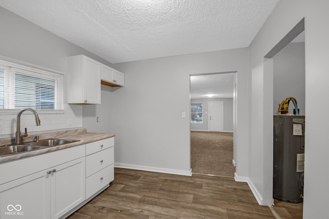 kitchen featuring sink, water heater, tasteful backsplash, white cabinets, and dark hardwood / wood-style flooring