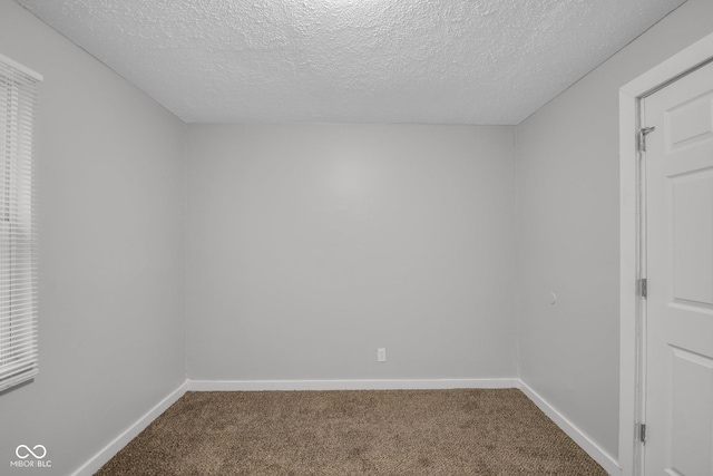 carpeted spare room featuring a textured ceiling