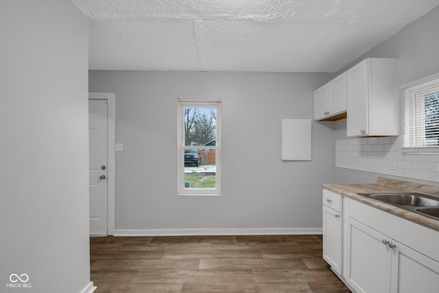 kitchen with white cabinetry, plenty of natural light, and light hardwood / wood-style floors