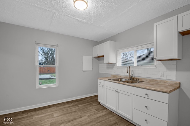 kitchen with white cabinetry, light hardwood / wood-style floors, and sink