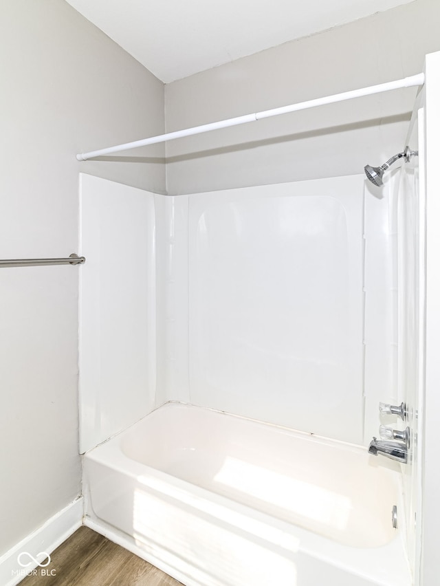 full bathroom featuring shower / bathtub combination, wood finished floors, and baseboards