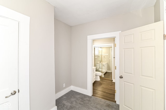 interior space featuring baseboards and dark colored carpet