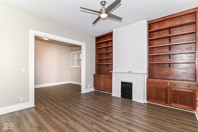 unfurnished living room featuring dark wood-style floors, a fireplace, and baseboards