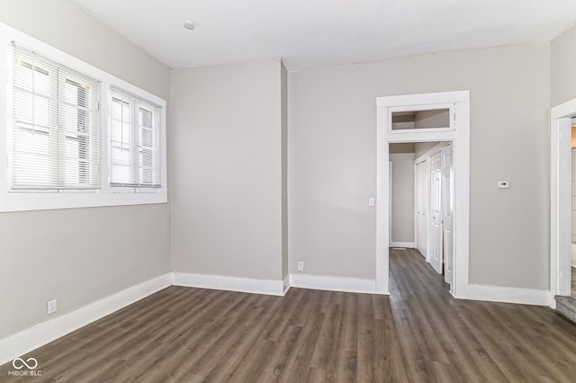 empty room with baseboards and dark wood-style flooring