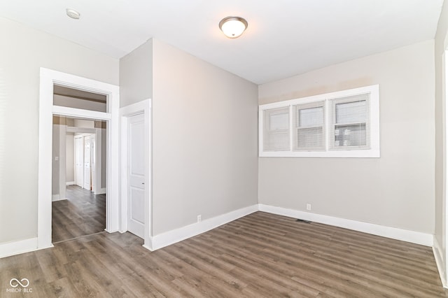 spare room with dark wood-style floors and baseboards