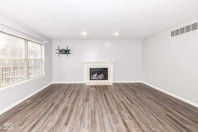 unfurnished living room with dark wood-type flooring and a fireplace