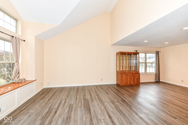 unfurnished living room featuring wood-type flooring and high vaulted ceiling