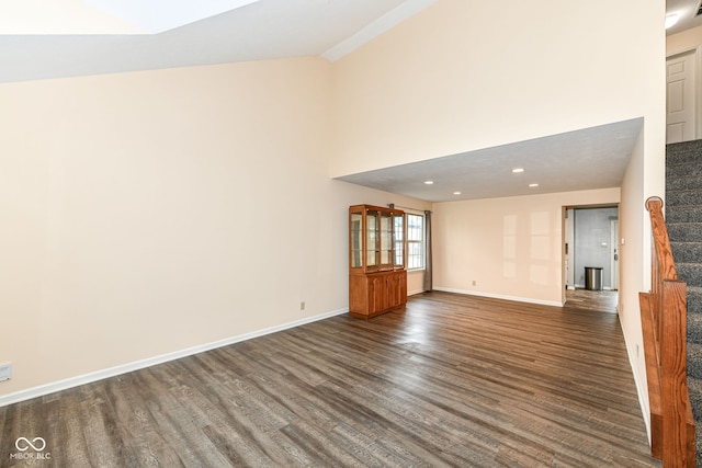 unfurnished living room featuring high vaulted ceiling and dark hardwood / wood-style floors