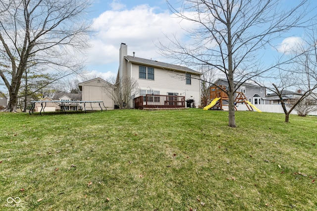 back of house with a playground, a swimming pool side deck, and a yard