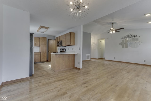 kitchen with lofted ceiling, ceiling fan with notable chandelier, light hardwood / wood-style flooring, and stainless steel appliances