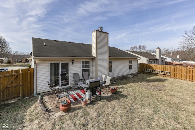 rear view of house featuring a lawn and a patio