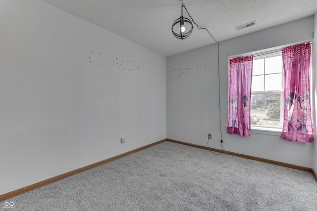 carpeted empty room with a textured ceiling