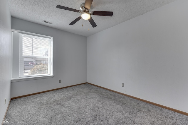 carpeted spare room featuring ceiling fan and a textured ceiling