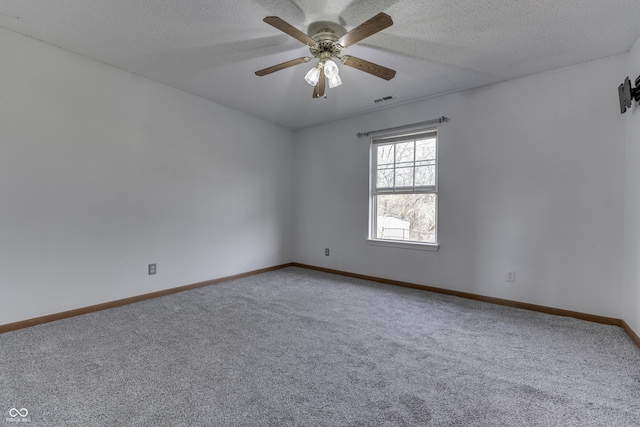 spare room with ceiling fan, a textured ceiling, and carpet flooring