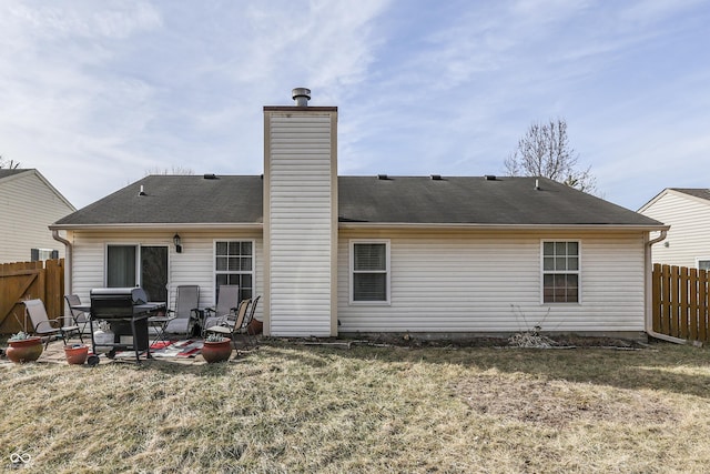 back of property with a yard and a patio