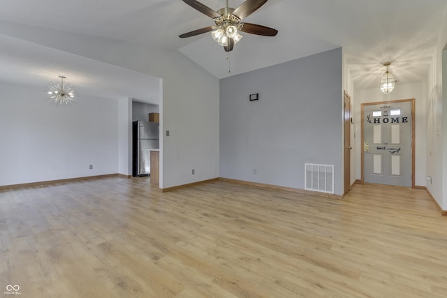 unfurnished living room featuring vaulted ceiling, ceiling fan with notable chandelier, and light wood-type flooring