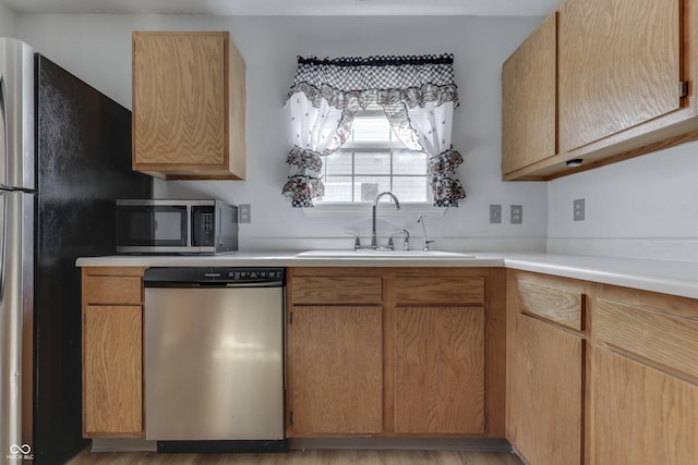 kitchen with stainless steel appliances, sink, and light brown cabinets