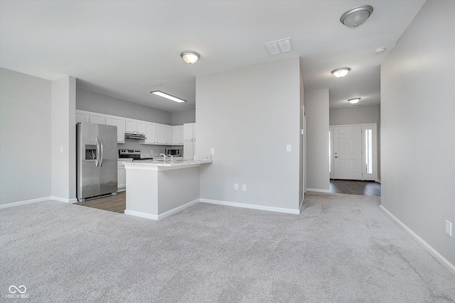 kitchen with white cabinetry, sink, dark colored carpet, kitchen peninsula, and stainless steel appliances