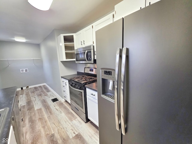 kitchen featuring stainless steel appliances, white cabinets, and light wood-type flooring