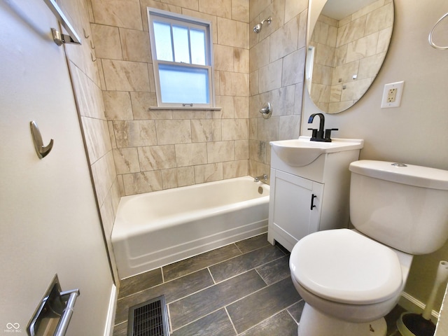 full bathroom with tiled shower / bath, vanity, and toilet