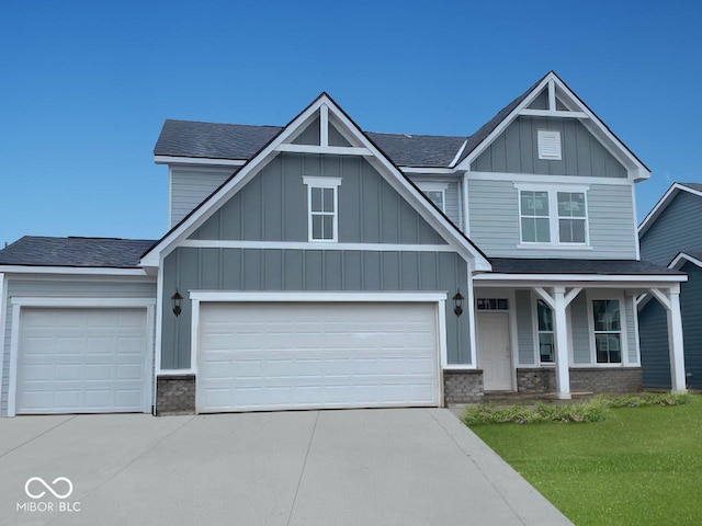 craftsman inspired home featuring a garage, concrete driveway, board and batten siding, and brick siding