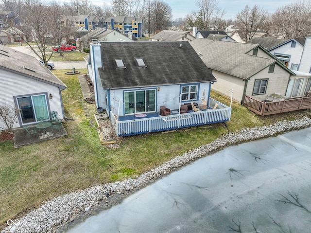 rear view of property with a deck and a lawn