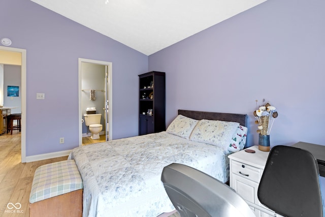 bedroom with lofted ceiling, light hardwood / wood-style flooring, and ensuite bathroom