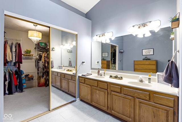 bathroom with vanity, tile patterned flooring, and an inviting chandelier