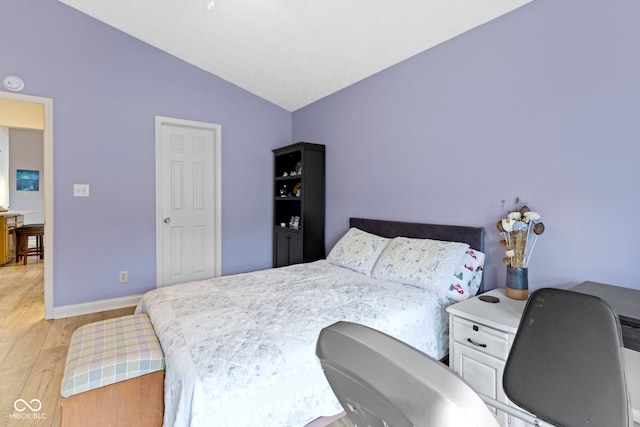 bedroom featuring lofted ceiling and light wood-type flooring