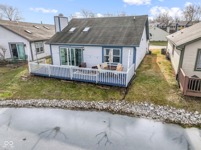 rear view of property with a wooden deck, cooling unit, and a lawn