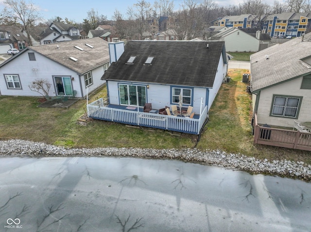 rear view of house featuring a wooden deck and a yard