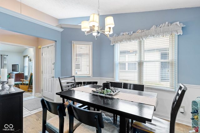 dining area with vaulted ceiling, a notable chandelier, and light hardwood / wood-style flooring