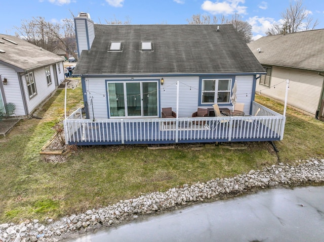 back of property with a wooden deck and a yard