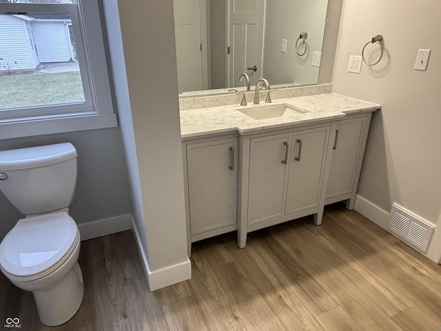 bathroom with vanity, toilet, and hardwood / wood-style floors