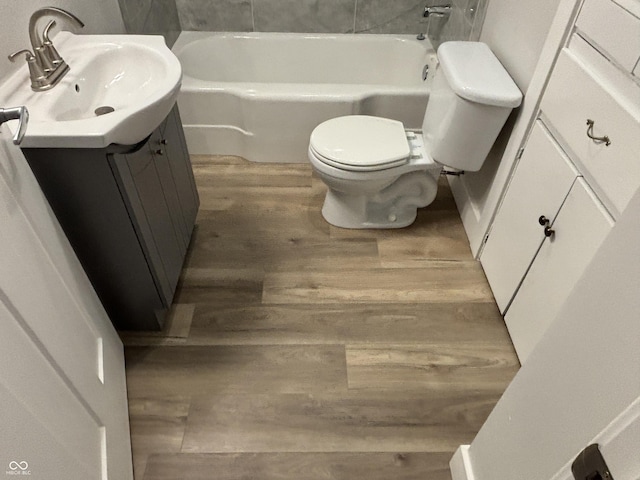 bathroom with vanity, wood-type flooring, a bathing tub, and toilet