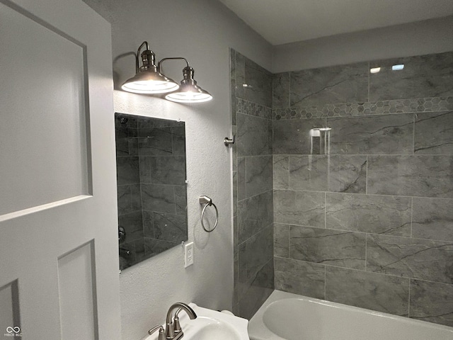 bathroom with sink and tiled shower / bath combo