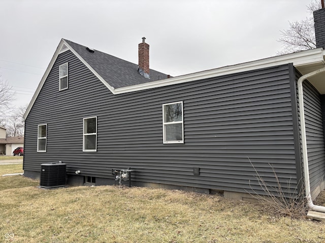 view of side of home featuring a yard and central air condition unit