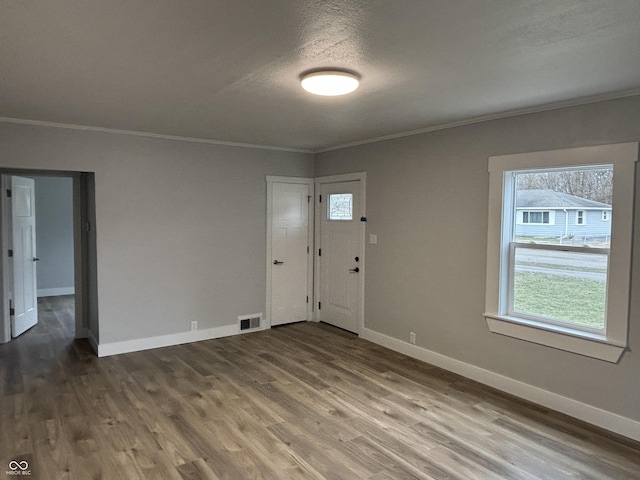 entryway featuring ornamental molding, hardwood / wood-style floors, and a textured ceiling