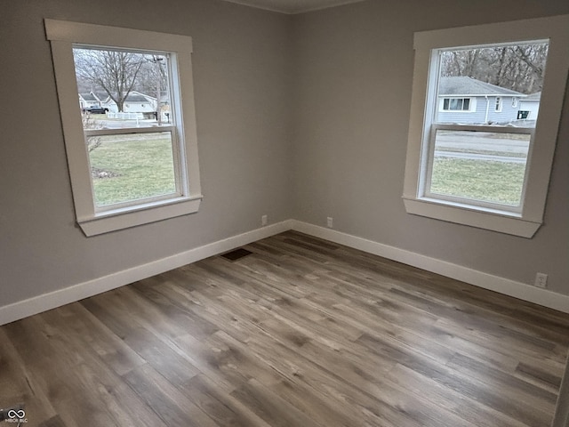 unfurnished room featuring a healthy amount of sunlight and hardwood / wood-style floors