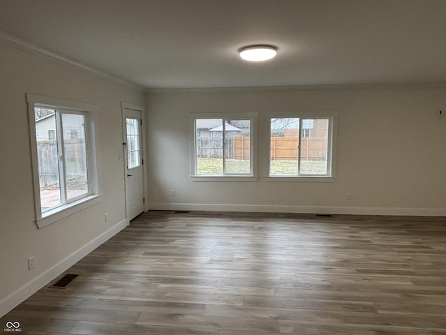 spare room featuring dark wood-type flooring and ornamental molding