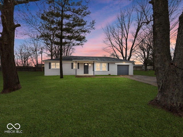 ranch-style house with a garage and a yard