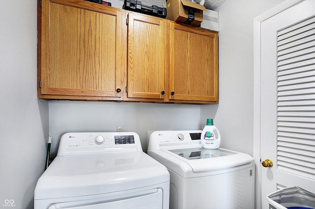 laundry room with cabinets and washer and clothes dryer