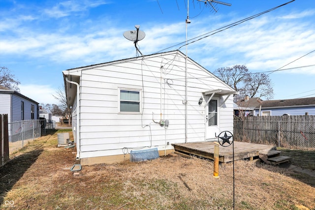 rear view of property featuring central AC, a yard, and a deck