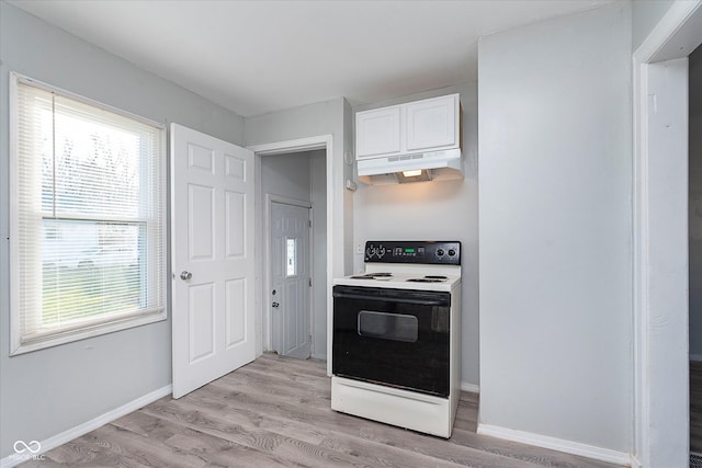 kitchen featuring light wood-style floors, under cabinet range hood, plenty of natural light, and electric range