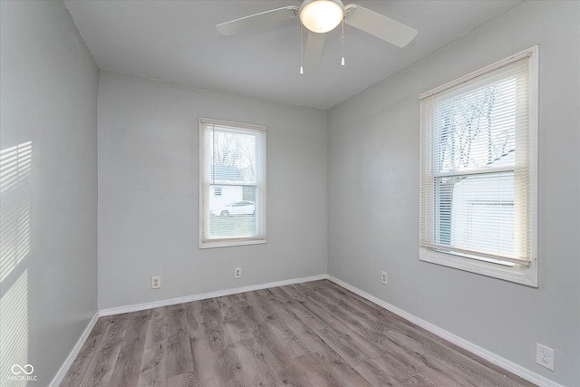 unfurnished room featuring a ceiling fan, baseboards, and wood finished floors