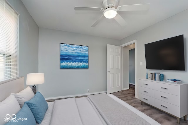 bedroom featuring wood finished floors, a ceiling fan, and baseboards