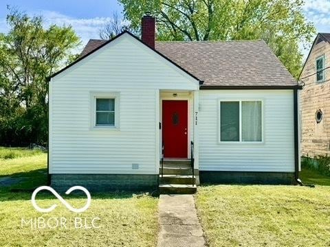 711 W 24th St, Anderson, IN 46016 - bungalow-style home with entry steps, a chimney, a front lawn, and a shingled roof